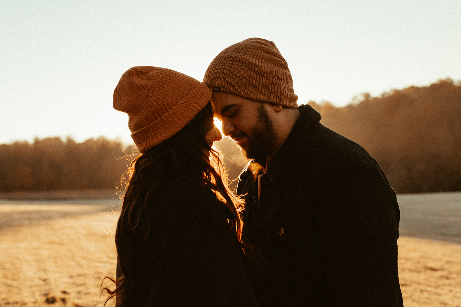 hispanic couple with beanies on during sunrise cincinnati engagement photo shoot