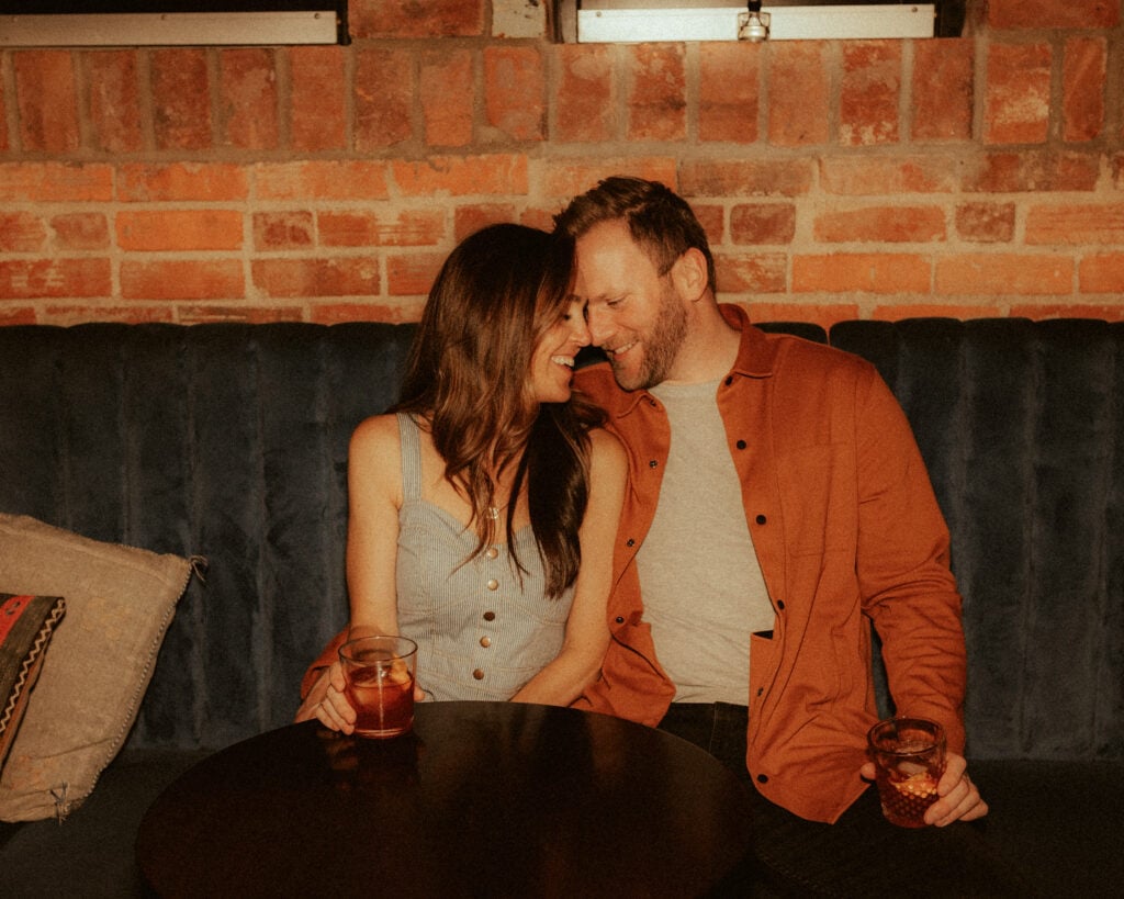 engagement photo of couple snugging at cincinnati cocktail bar