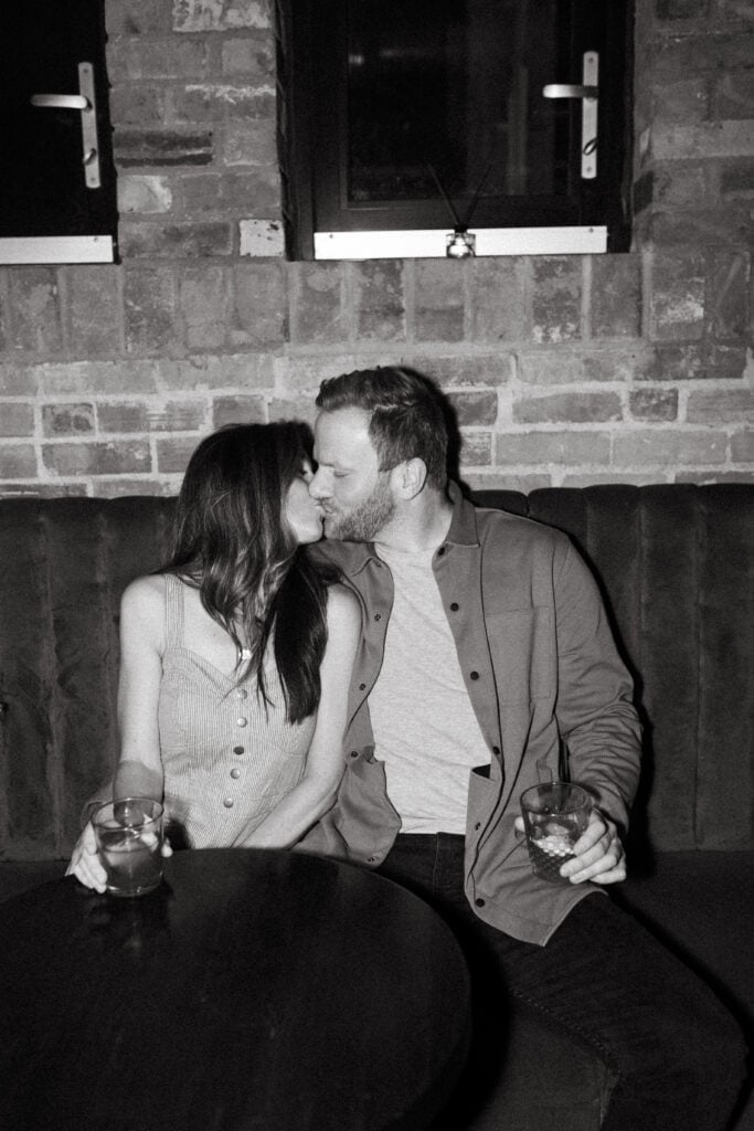 black and white engagement photo of couple kissing at cincinnati cocktail bar