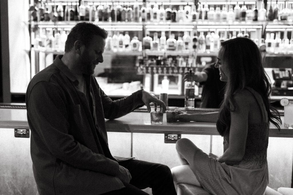 engagement photo of couple sitting at a cocktail bar in cincinnati