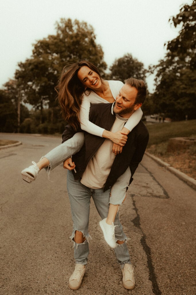 swinging piggy back ride pose for candid engagement photo