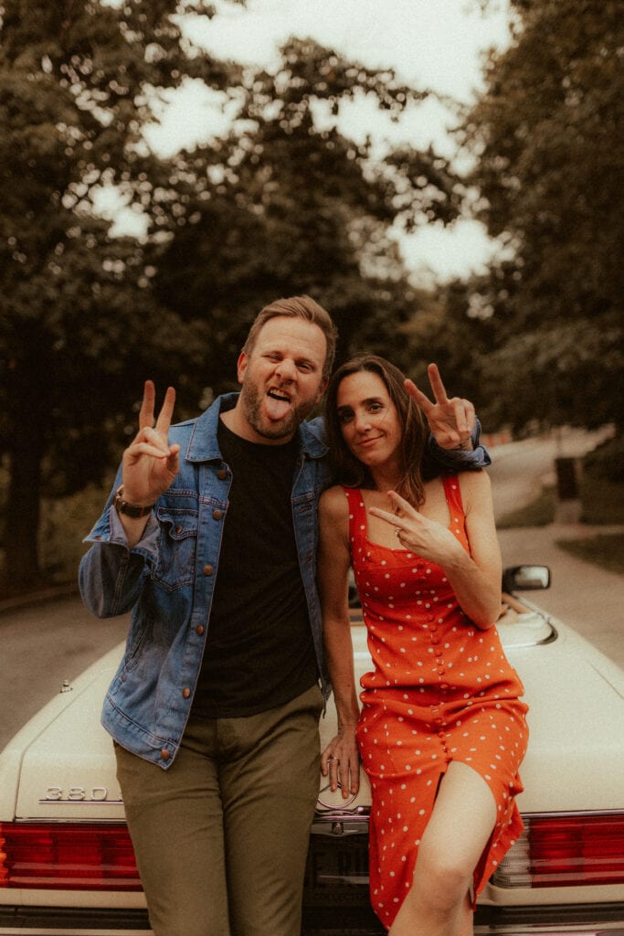 couple throwing up peace signs at cincinnati engagement photographer
